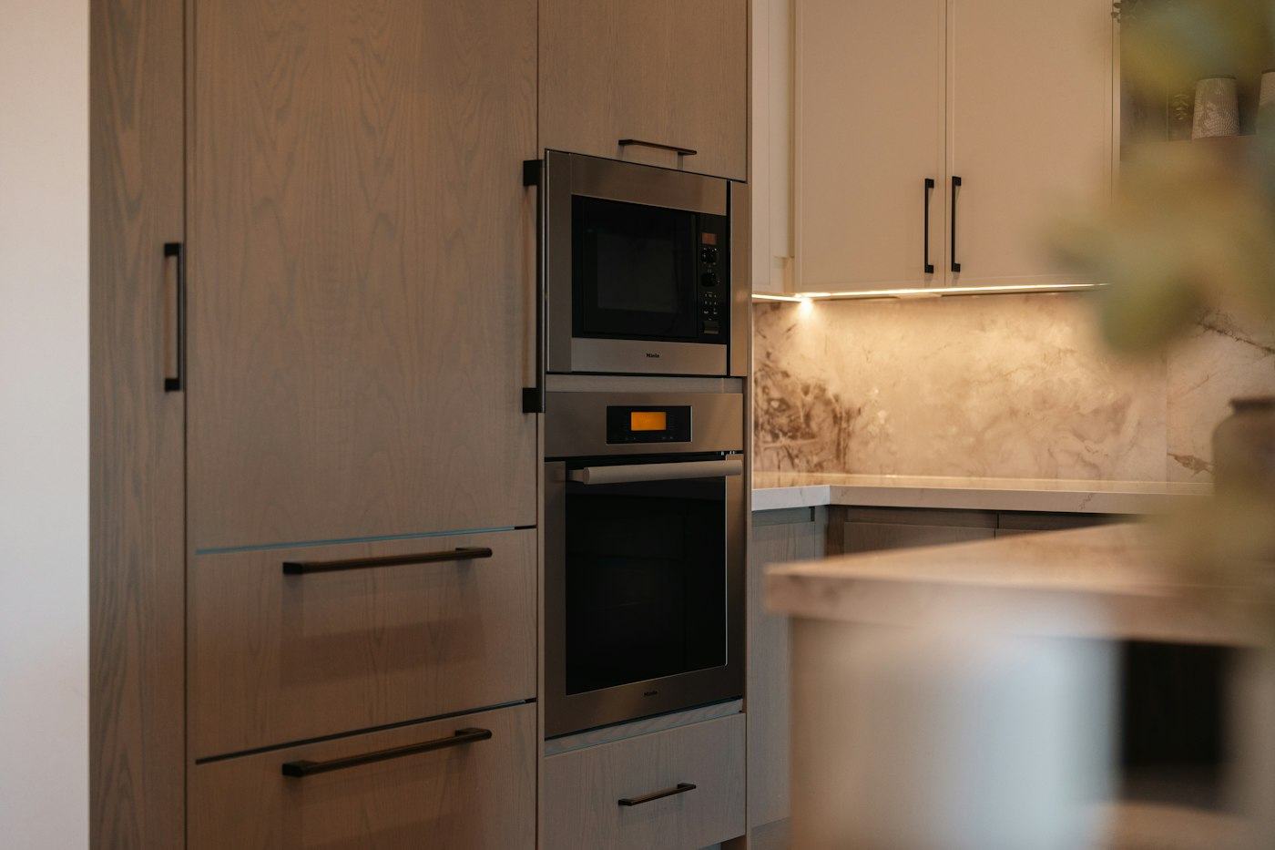 Tall wood cabinets with built-in oven and microwave