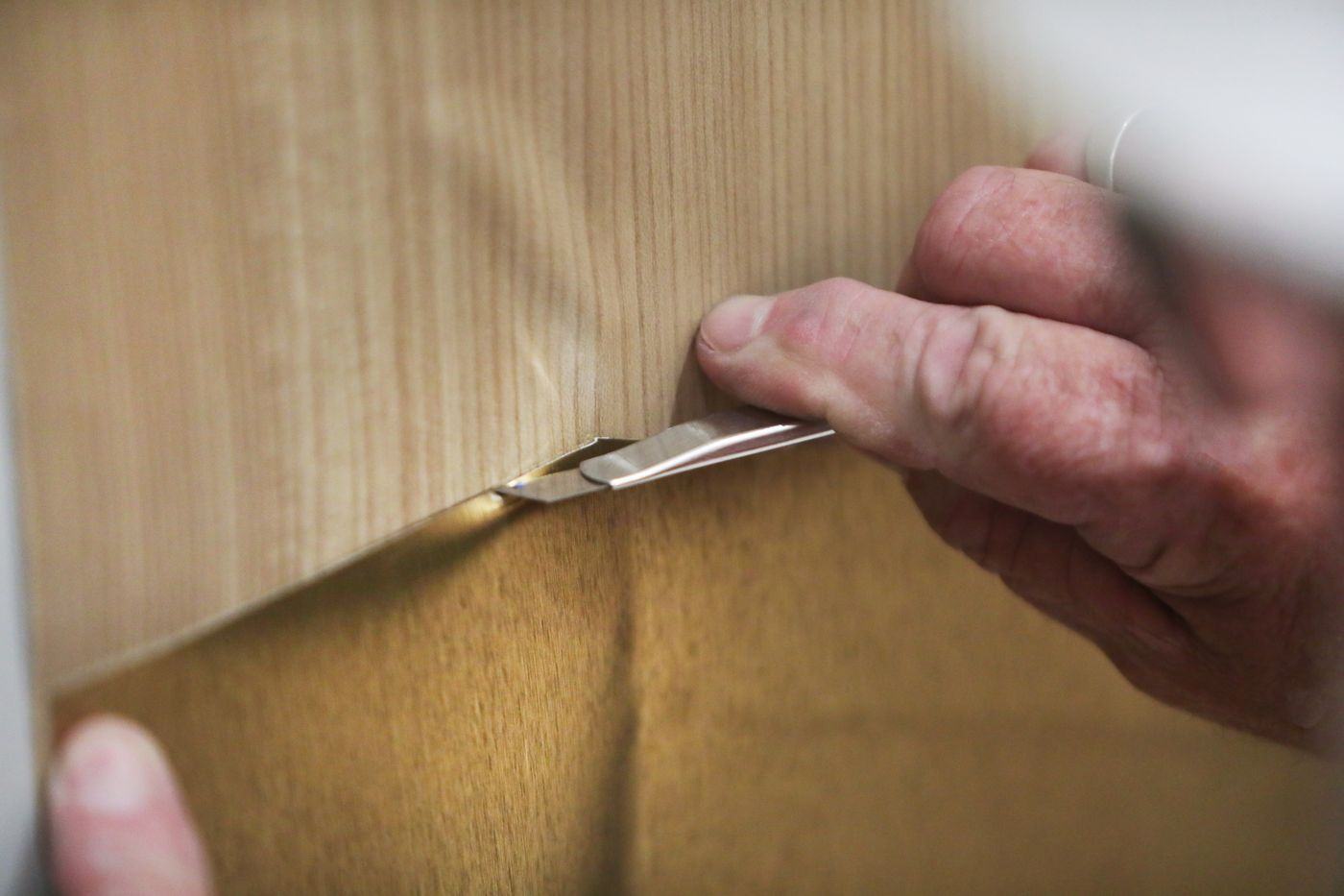 Hand smoothing woodgrain film onto a surface